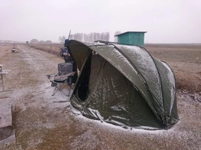 Зимняя рыбалка на карпа с палаткой-bivvy на заснеженном берегу водоема
