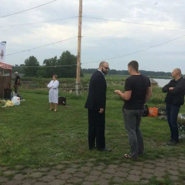 Священник проводит освящение места проведения карпфишинг соревнований на берегу водоема