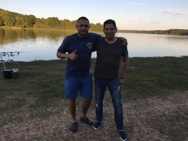 Два карпятника на рыбалке у водоёма на закате с карповыми удилищами